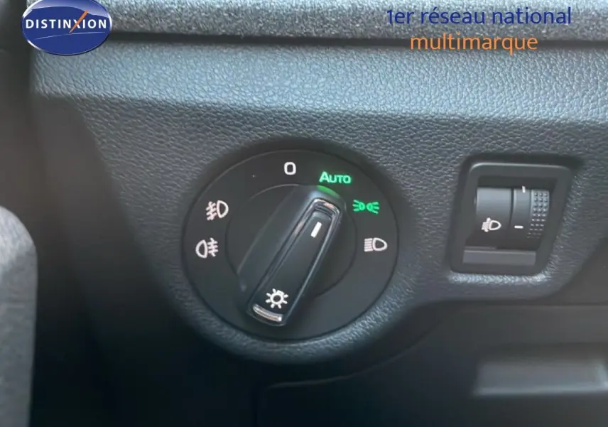 Gros plan sur le bouton de commande des phares du Skoda Kamiq 2025 en intérieur gris noir.