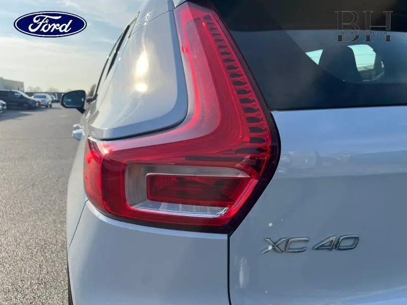 Gros plan sur le feu arrière droit d’un Volvo XC40 gris Glacier, avec le logo et le badge du modèle visibles.