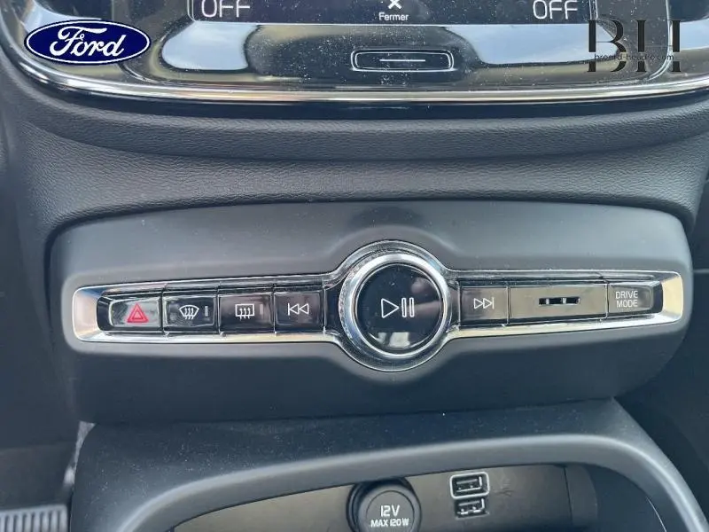 Détail de la console centrale noire avec commandes multimédia et bouton Drive Mode sur Volvo XC40 Gris Glacier 2021.