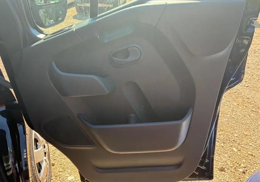 Vue intérieure de la porte côté gauche du Renault Master gris 2023, avec poignée et rangement intégré.