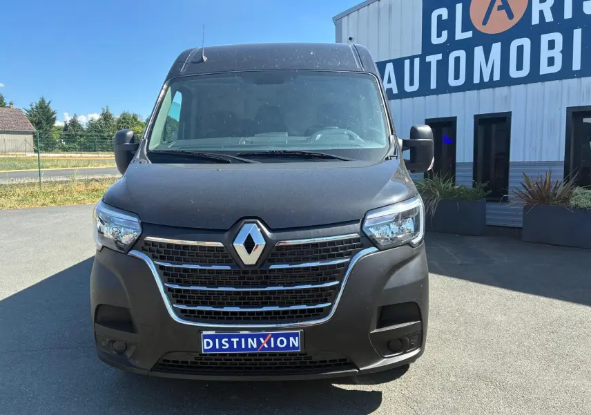 Vue avant d’un Renault Master gris 2023 avec calandre chromée et logo Renault bien visible, stationné devant un bâtiment.