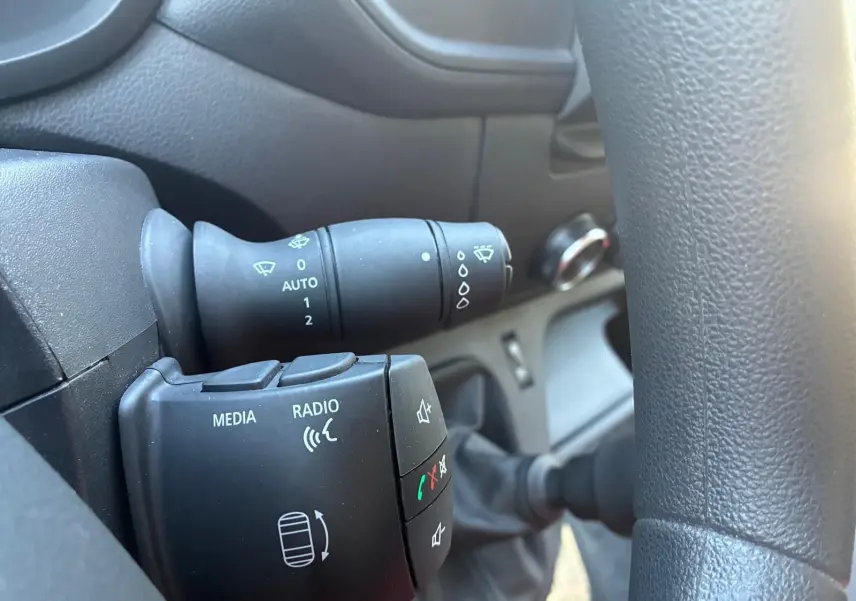 Gros plan sur la commande au volant du Renault Master 2023 gris, avec boutons média, radio et commandes d’essuie-glace.