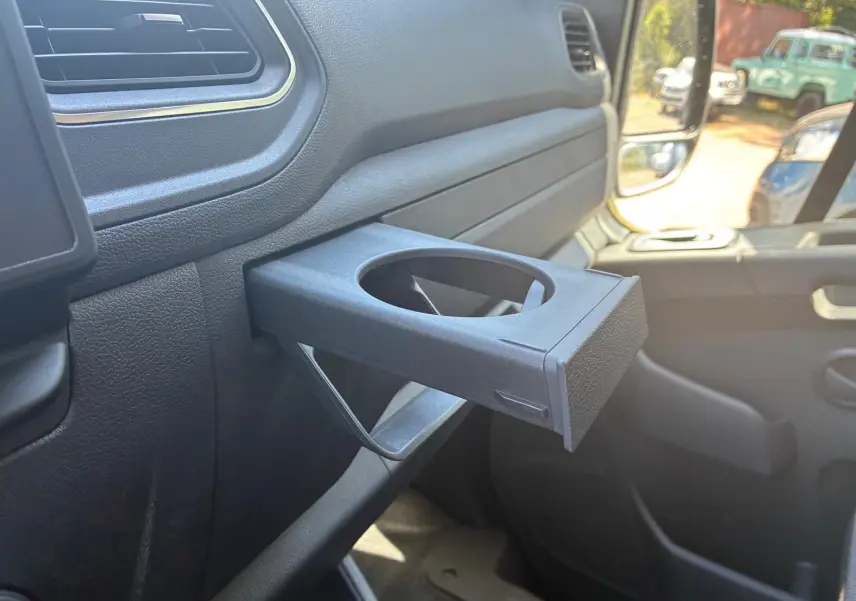 Détail intérieur du porte-gobelet déployé côté passager du Renault Master gris 2023, vue rapprochée.