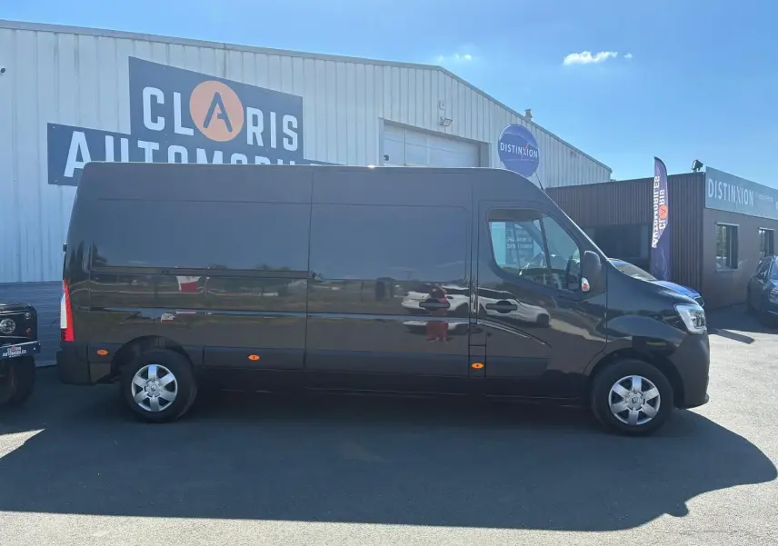 Vue de profil côté droit d’un Renault Master gris 2023, fourgon long avec jantes acier et vitres teintées.
