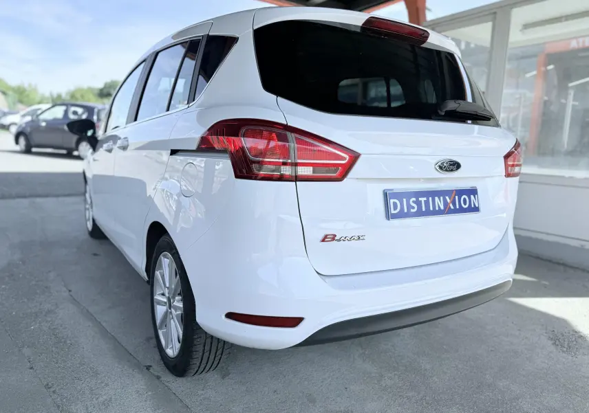 Vue 3/4 arrière droite d'une Ford B-MAX blanche de 2017 avec feux arrière distinctifs et plaque Distinxion.