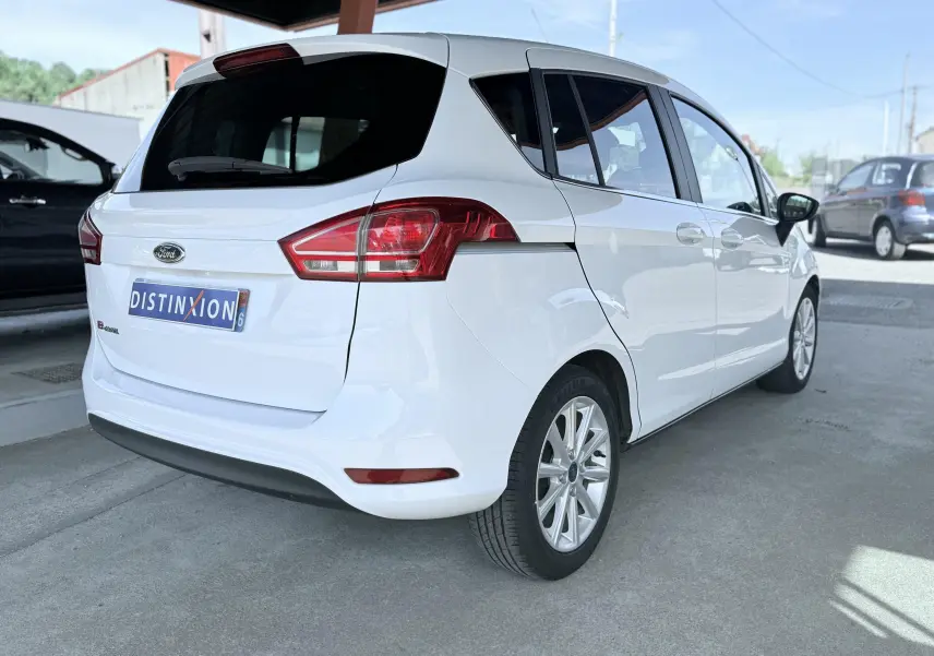 Vue 3/4 arrière droite d'une Ford B-MAX blanche de 2017 avec feux arrière rouges et jantes alliage.
