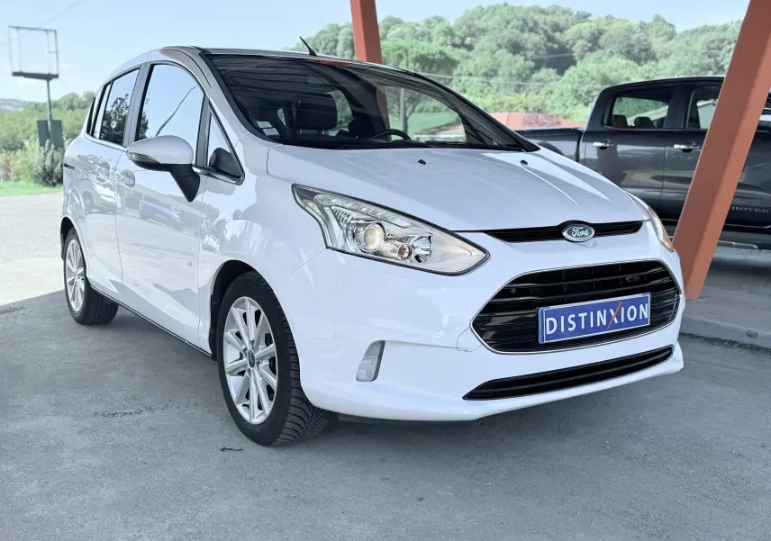 Ford B-MAX blanc vue 3/4 avant droit, mettant en valeur la calandre noire et les phares distinctifs.