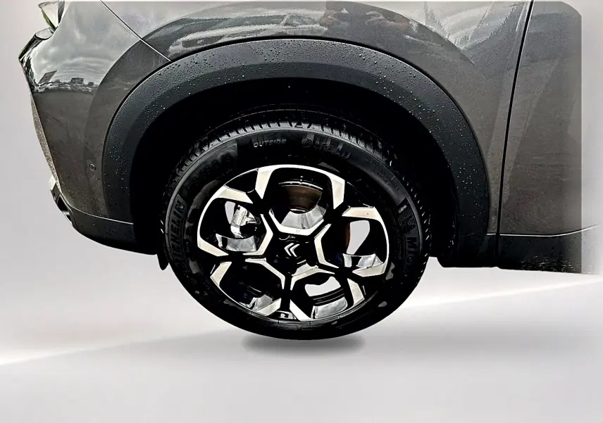 Gros plan sur la roue avant droite du Citroën C5 Aircross gris platinium avec jante alu au design moderne.