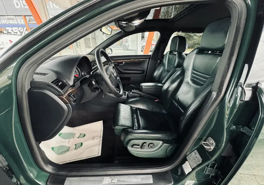 Vue côté gauche de l'intérieur vert foncé cuir de l'Audi S4 Avant 2004 avec sièges électriques et volant multifonction.