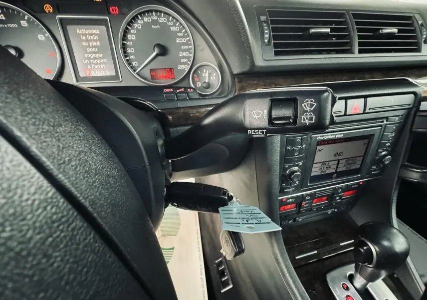 Vue rapprochée du tableau de bord et levier de vitesses automatique d'une Audi S4 Avant 2004, intérieur noir.