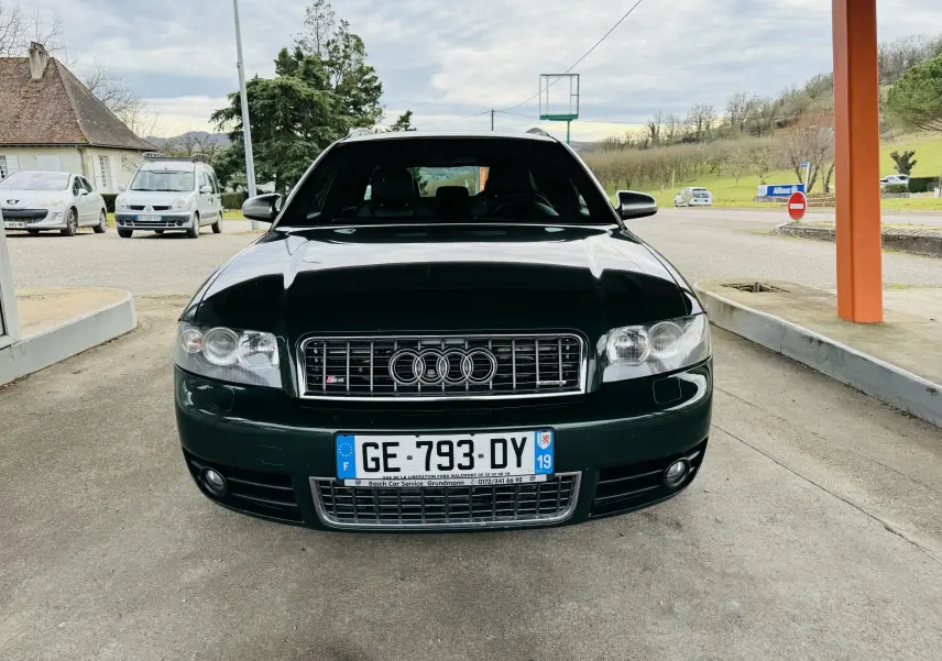 Vue frontale d'une Audi S4 Avant 2004 vert foncé avec calandre chromée et phares doubles ronds.