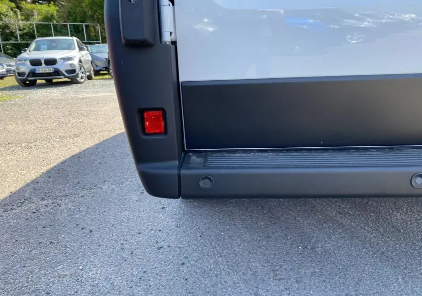 Gros plan sur le bas du hayon arrière blanc du Peugeot Boxer Fourgon avec radar de recul visible.