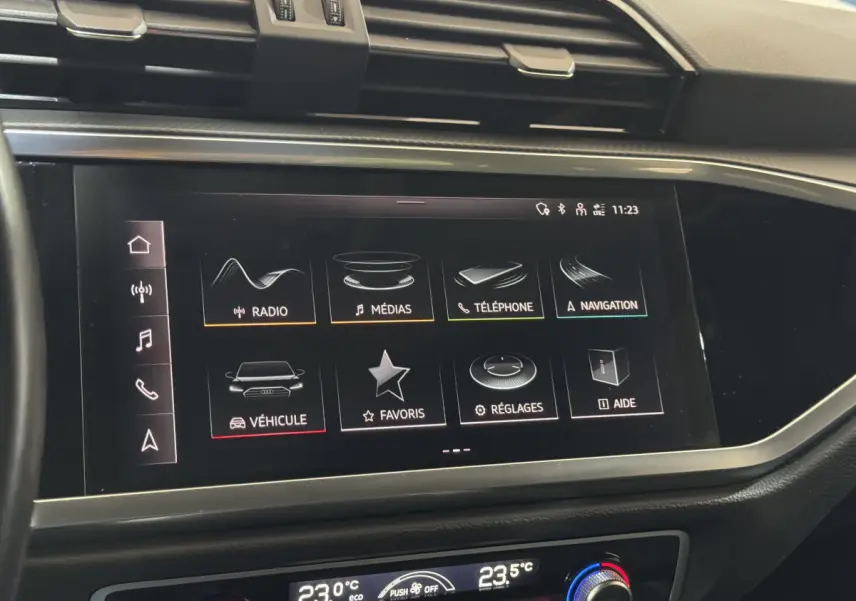 Écran tactile central de l'Audi Q3 35 TFSI 2022 affichant les menus radio, médias, téléphone et navigation, vue intérieure frontale.