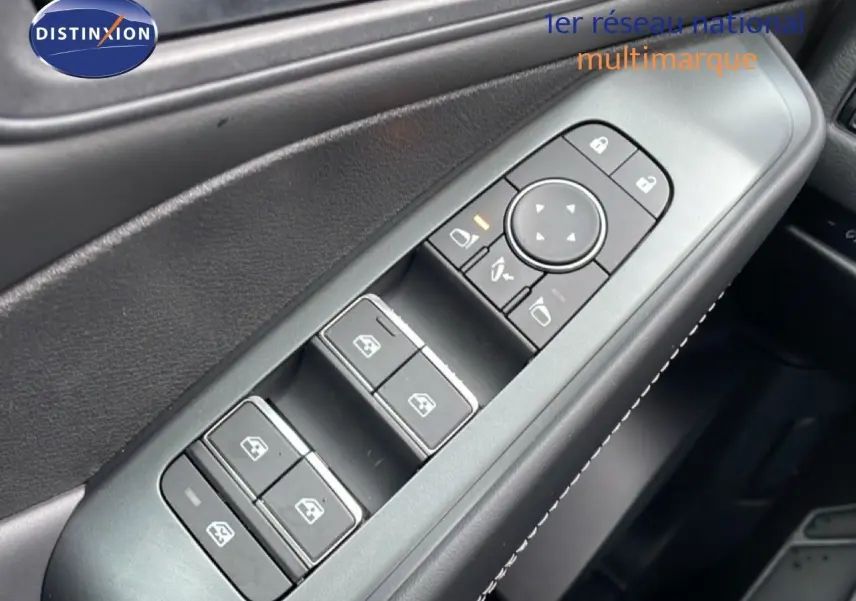 Gros plan sur les commandes des vitres et rétroviseurs côté gauche du Nissan Qashqai blanc nacré 2025.