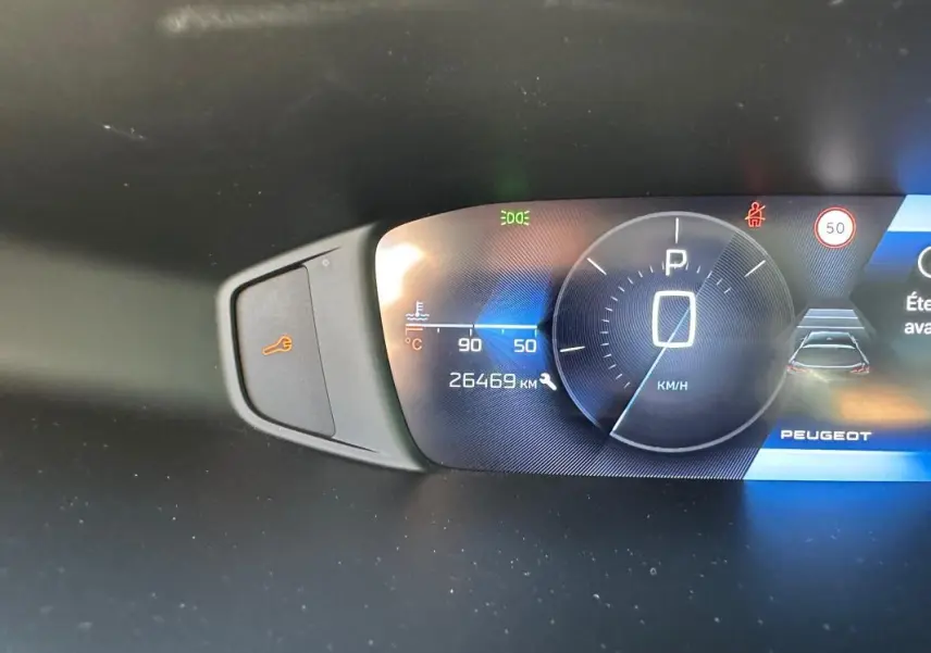 Tableau de bord numérique de Peugeot 308 SW Hybrid noir, affichant vitesse à 0 km/h et 26 469 km au compteur.