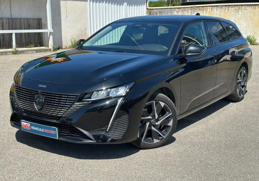 Peugeot 308 SW Hybrid noir vue 3/4 avant droit, avec jantes alliage 17 pouces et calandre distinctive.