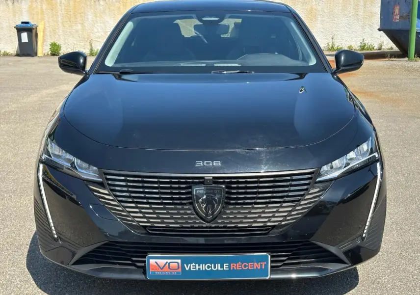 Vue frontale d'une Peugeot 308 SW Hybrid 145 noire, mettant en valeur sa calandre moderne et ses phares LED fins.