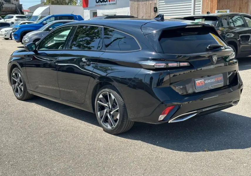 Peugeot 308 SW Hybrid noir vue 3/4 arrière droit, avec jantes alliage 17 pouces et feux arrière LED distinctifs.