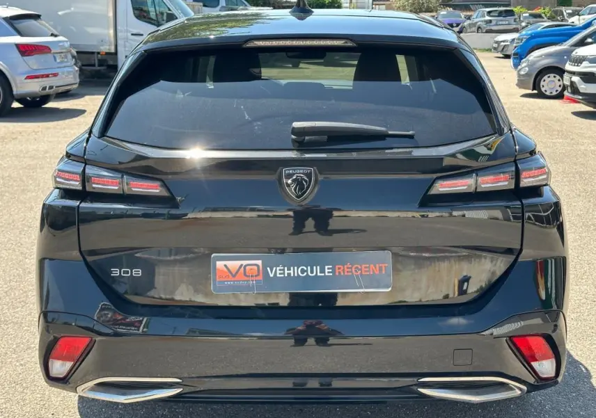 Vue arrière d'une Peugeot 308 SW Hybrid noire de 2025, avec feux LED caractéristiques et badge central Peugeot.