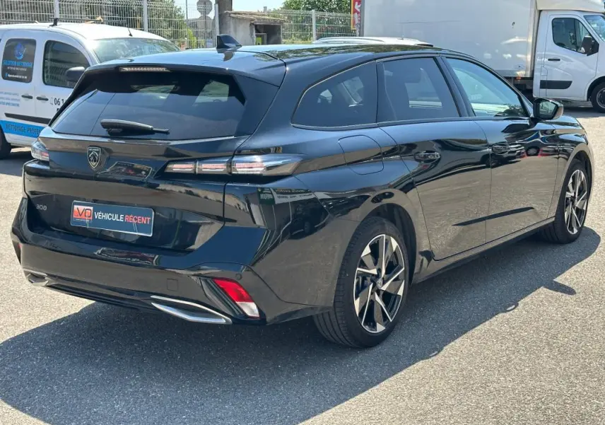 Peugeot 308 SW Hybrid noir vue 3/4 arrière droit, jantes alliage 17 pouces et feux arrière LED distinctifs.