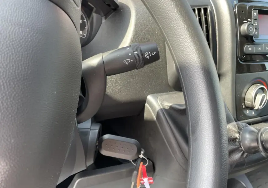 Intérieur du Peugeot Boxer Fourgon blanc 2023, vue rapprochée du volant, levier de vitesses et commandes au tableau de bord.