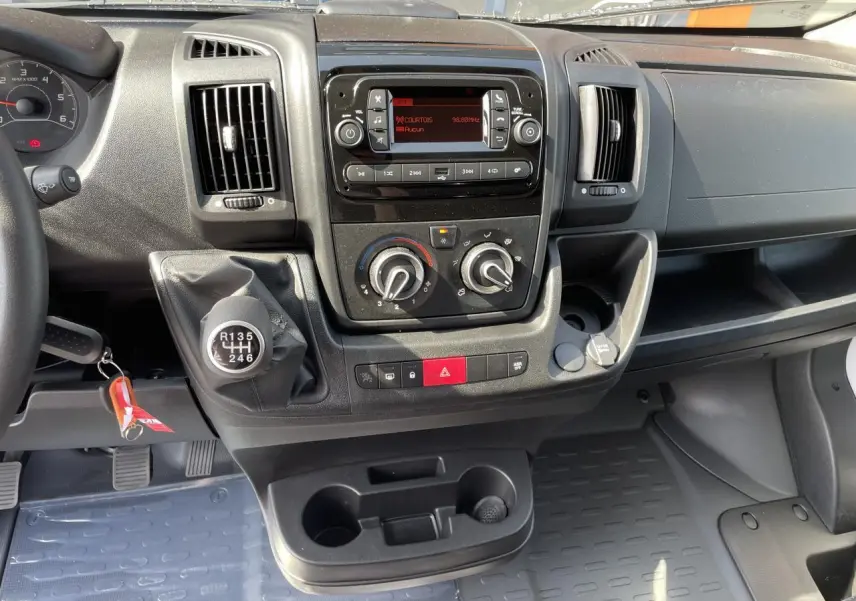 Vue rapprochée du tableau de bord du Peugeot Boxer Fourgon blanc 2023 avec boîte manuelle et commandes de climatisation.