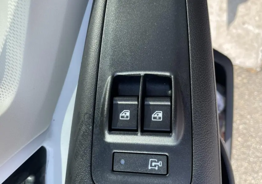 Gros plan sur les commandes de lève-vitres et réglage des rétroviseurs côté gauche du Peugeot Boxer Fourgon blanc 2023.