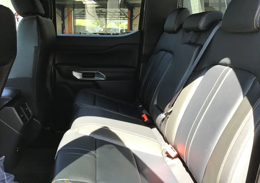 Vue intérieure côté droit des sièges arrière en cuir noir avec surpiqûres contrastantes du Ford Ranger Double Cabine 2025.