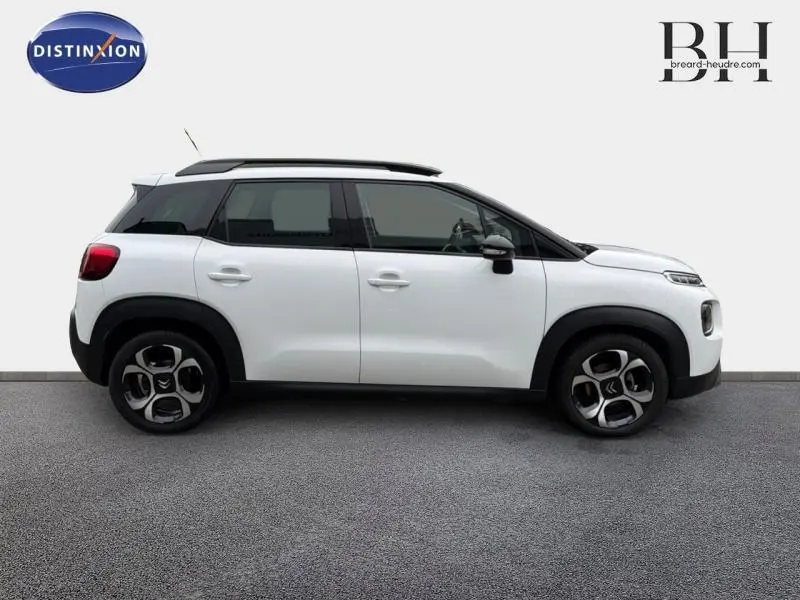 Vue de profil droit d'un Citroën C3 Aircross 2018 blanc Natural White avec barres de toit et jantes diamantées.