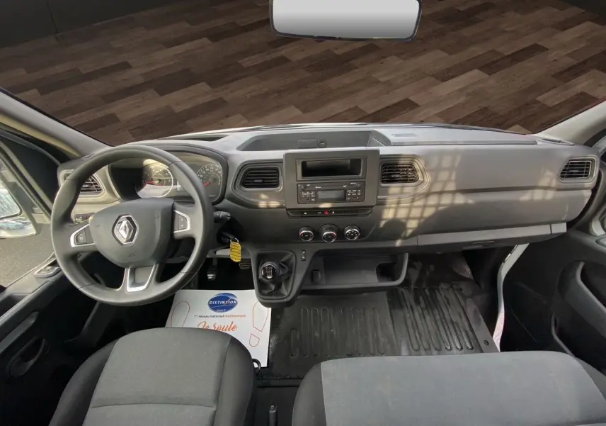 Vue intérieure avant du Renault Master 2024, tableau de bord noir avec volant multifonction et boîte manuelle.