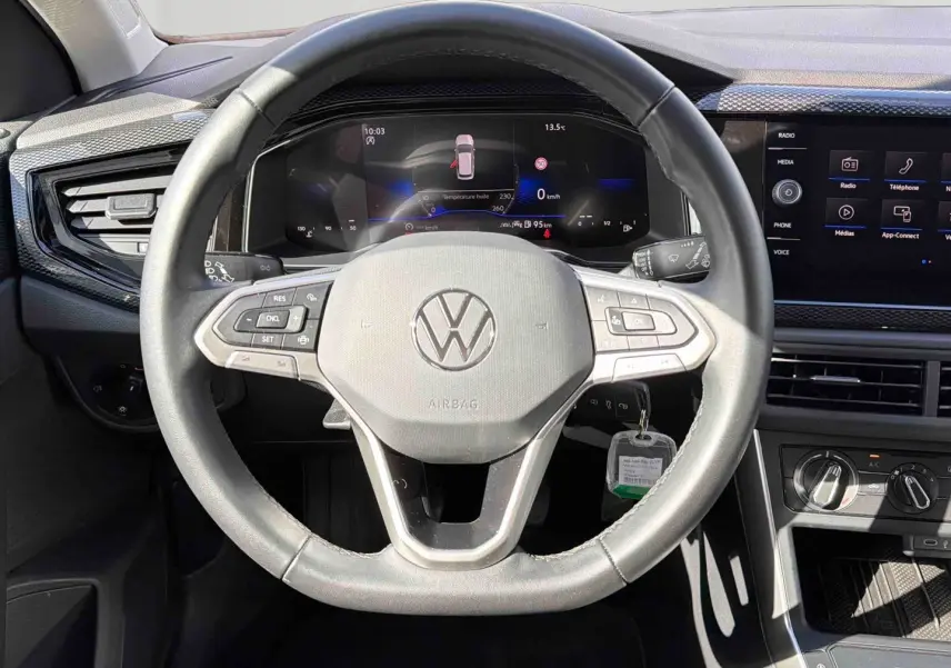 Vue frontale du volant cuir noir et du tableau de bord digital de la Volkswagen Polo 2025 avec écran tactile et commandes intégrées.