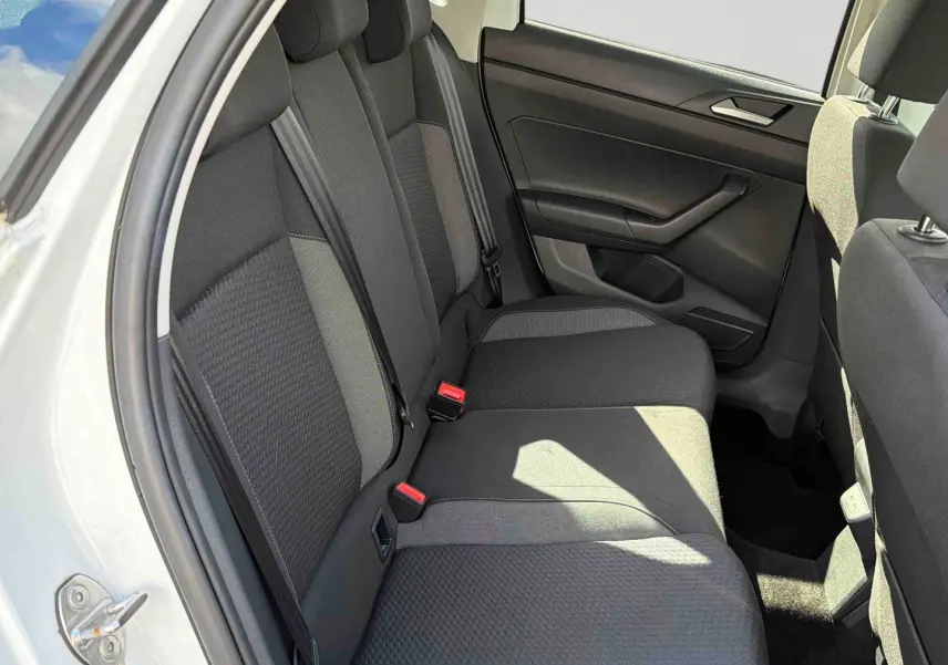 Vue intérieure côté arrière gauche montrant la banquette arrière grise d'une Volkswagen Polo blanche 2025.