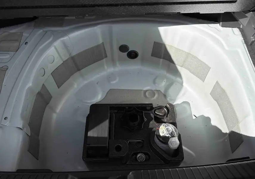 Coffre ouvert montrant la roue de secours blanche et un kit d’outils noir au centre du Volkswagen Polo 2025.