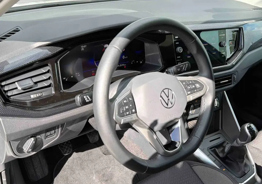 Vue intérieure côté conducteur du volant cuir et tableau de bord digital de la Volkswagen Polo 2025 avec boîte manuelle.