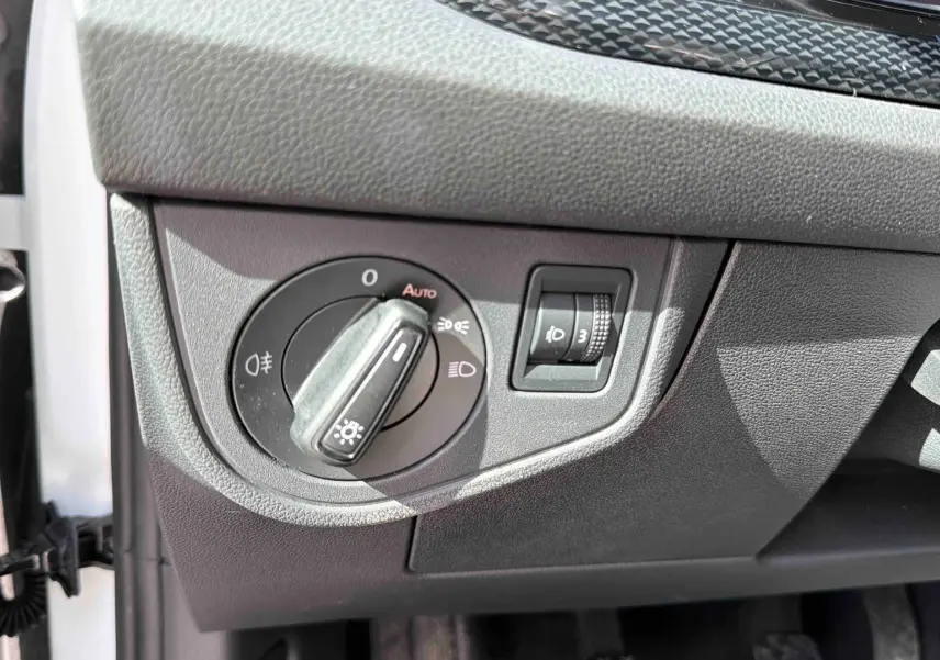Détail du bouton de commande des feux sur le tableau de bord côté gauche d’une Volkswagen Polo blanche 2025.
