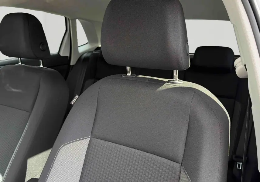 Gros plan sur le siège avant droit noir de la Volkswagen Polo 2025, intérieur tissu avec étiquette airbag visible.