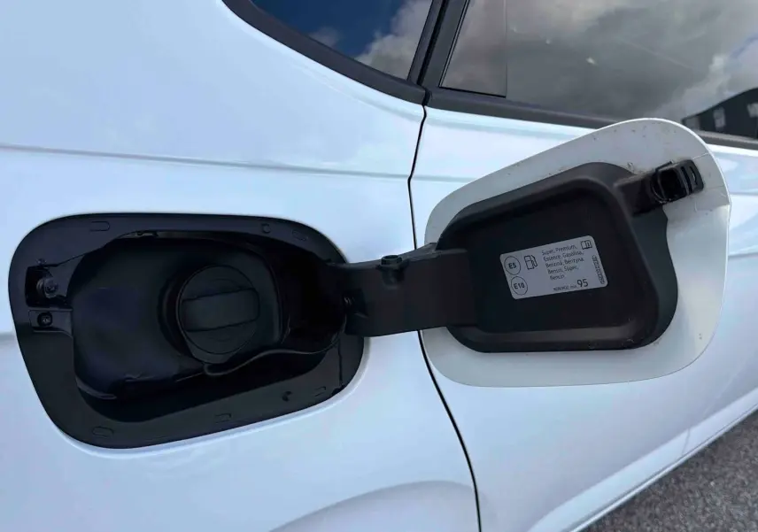 Gros plan sur la trappe à carburant ouverte côté gauche d'une Volkswagen Polo blanche essence 2025.