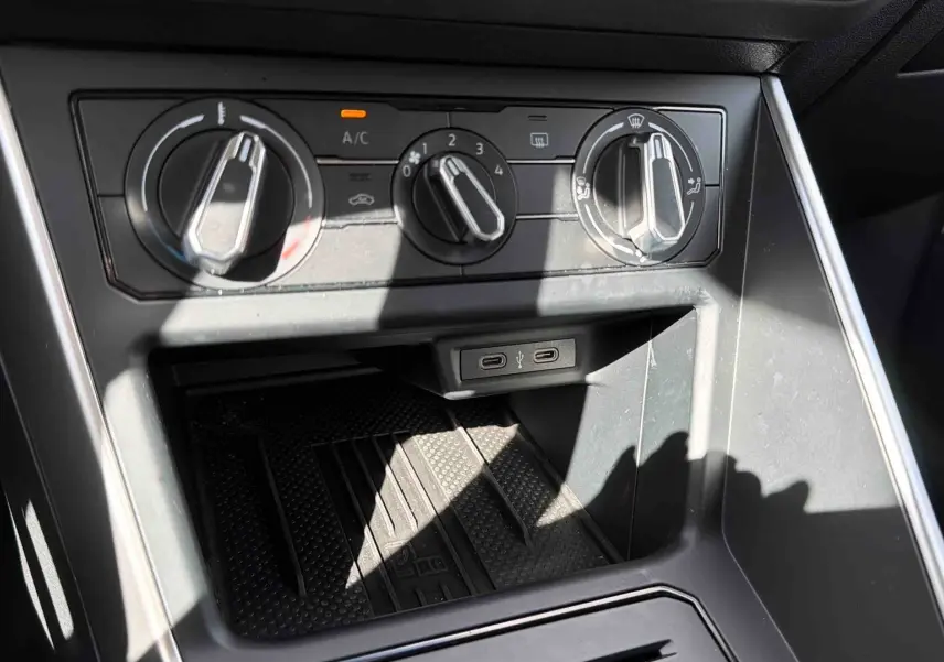 Gros plan sur les commandes de climatisation et les ports USB-C du tableau de bord d’une Volkswagen Polo blanche.