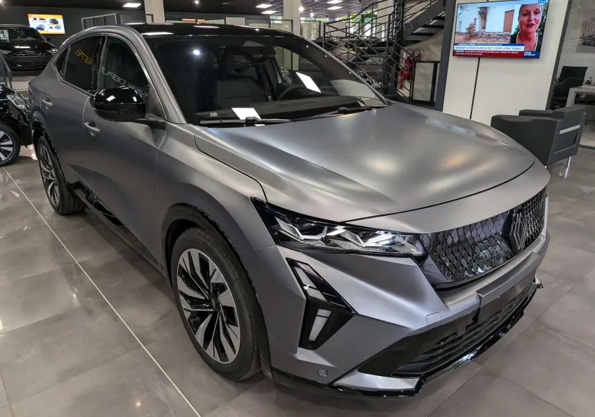 Vue 3/4 avant droite du Renault Rafale gris schiste satin avec calandre noire texturée et phares LED distinctifs.