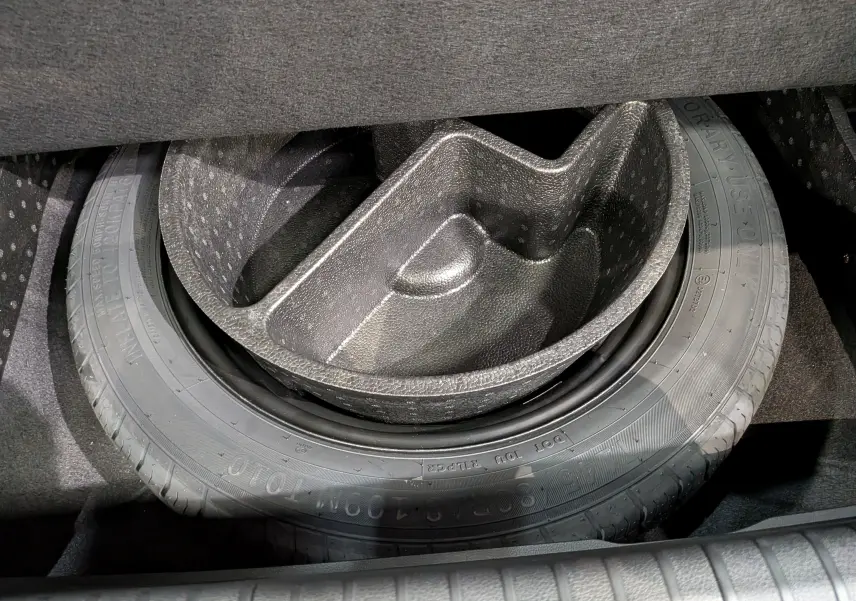 Vue rapprochée de la roue de secours et de son compartiment dans le coffre du Renault Rafale gris Schiste Satin.