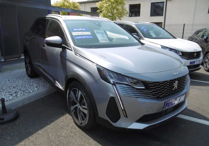 Peugeot 3008 hybride gris Artense en 3/4 avant droit, avec calandre noire et feux LED distinctifs.