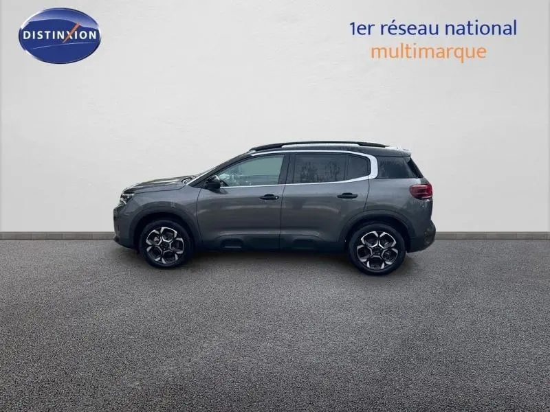 Profil côté gauche du Citroën C5 Aircross gris Platinium avec barres de toit et jantes alu distinctives.