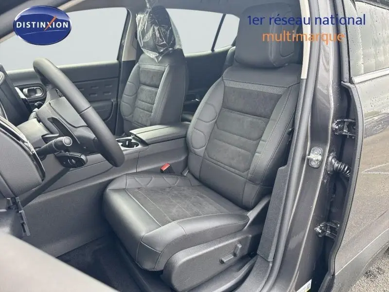 Vue intérieure côté conducteur du Citroën C5 Aircross gris Platinium, sièges en tissu noir avec cuir et volant multifonction.