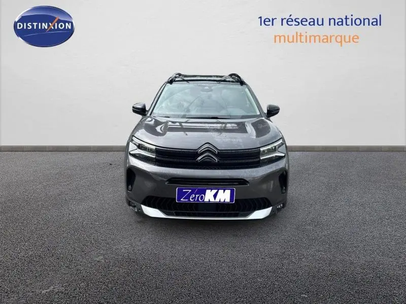 Vue frontale d'un Citroën C5 Aircross gris Platinium avec barres de toit et calandre noire distinctive.