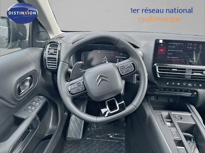 Vue intérieure centrée sur le volant cuir multifonction et tableau de bord numérique du Citroën C5 Aircross 2025.