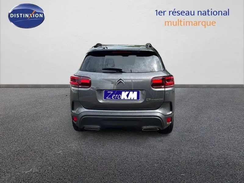 Vue arrière d'un Citroën C5 Aircross gris Platinium avec feux LED et barres de toit visibles sur fond neutre.