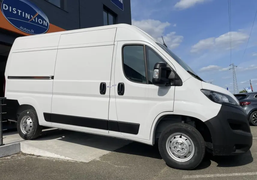 Peugeot Boxer Fourgon blanc en vue de profil côté gauche, avec porte latérale coulissante et jantes acier.