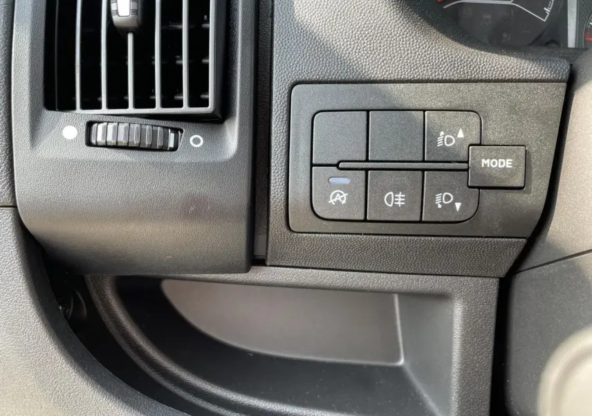 Détail du tableau de bord du Peugeot Boxer Fourgon 2023 montrant les commandes des phares et la ventilation côté gauche.