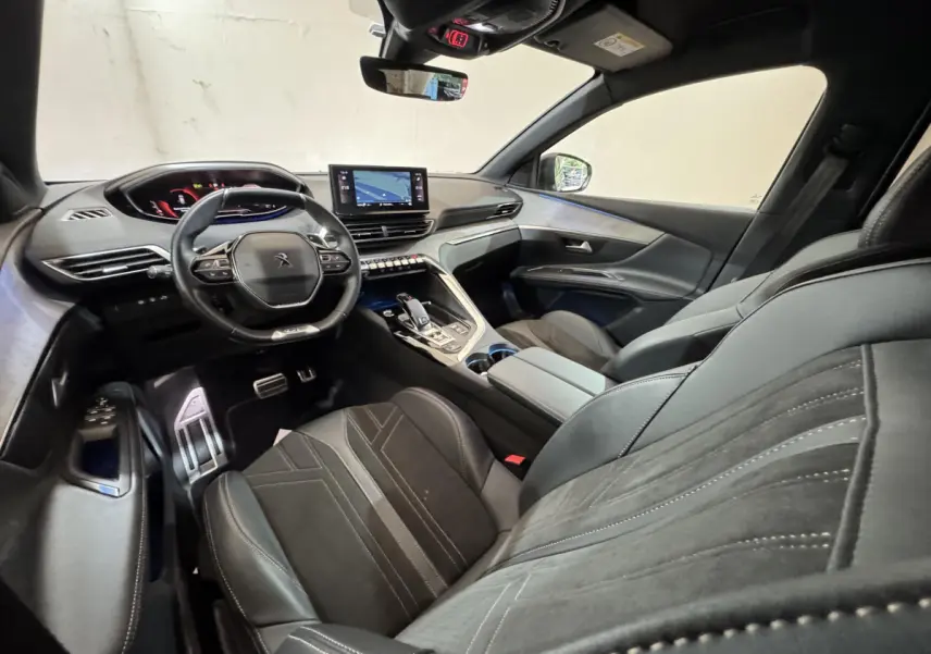 Vue intérieure côté conducteur du Peugeot 3008 GT 2021, sièges cuir noirs et tableau de bord digital avec écran tactile central.