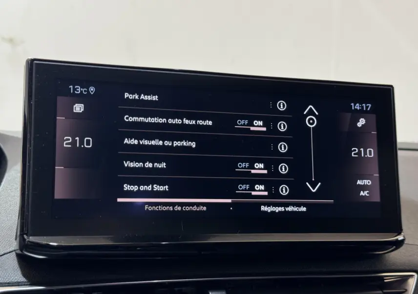 Écran tactile central du Peugeot 3008 GT 2021 affichant les réglages d’aide au stationnement et climatisation à 21°C.